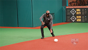 Harold Reynolds crouches to scoop a bounding grounder.