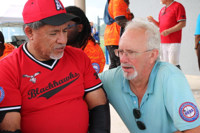 An Austin Blackhawks player talks with an umpire in the concession area.