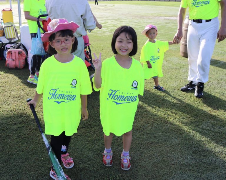 Two young girls dressed in Taiwan Homerun shirts pose for the camera.