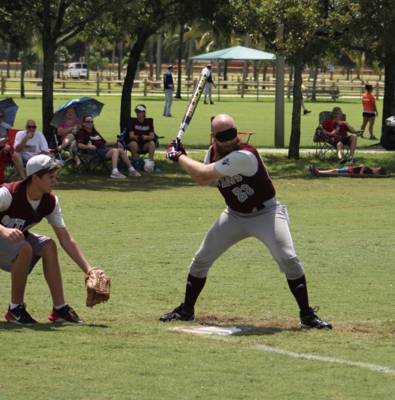 The BCS Outlaws' #23 in batting stance while the catcher readies himself.