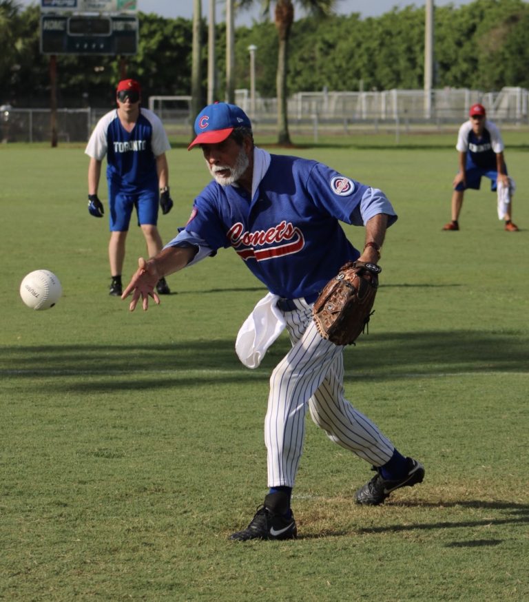 The Chicago Comets' pitcher releases the ball while the Toronto Blind Jays eagerly wait.