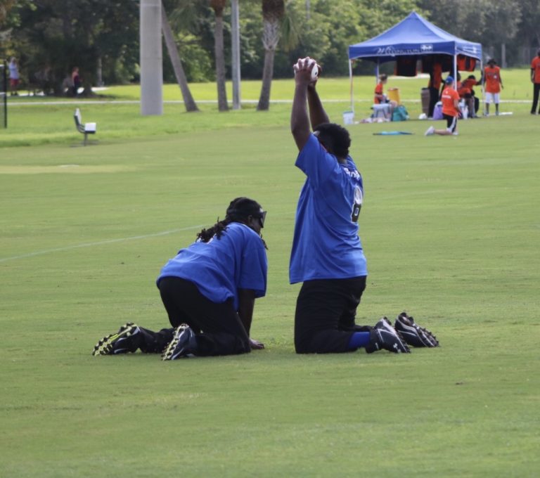 Two players dressed in blue successfully field the ball.