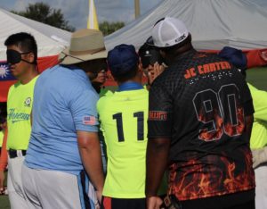 Umpire David Robert' and Coaches of Houston and Taiwan checking blindfolds before a game.