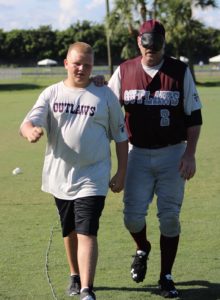 Knox "Sapo" Ward leading BCS's Craig Cotton back to the bench after scoring a run.
