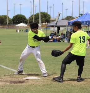 Taiwanese player about to pound the ball as the catcher #19 Johny Song moves back out of the way.