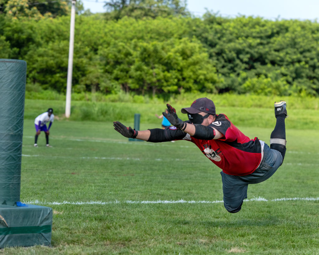Philly Fire's Johnny Margist diving head first in mid air to third base