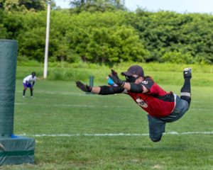 Philly Fire's Johnny Margist diving head first in mid air to third base